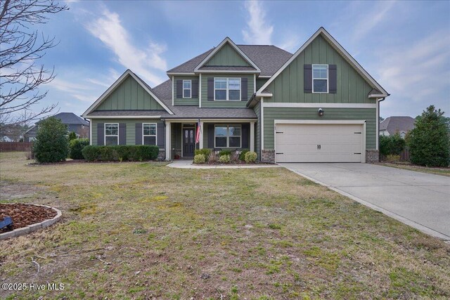 craftsman house featuring a front yard, driveway, roof with shingles, an attached garage, and board and batten siding
