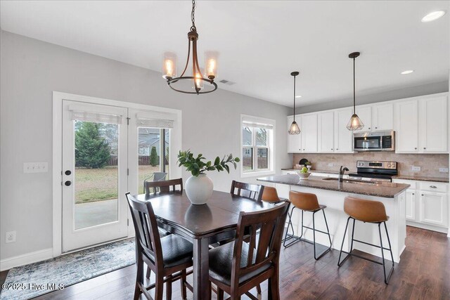dining space with visible vents, dark wood-type flooring, baseboards, recessed lighting, and an inviting chandelier