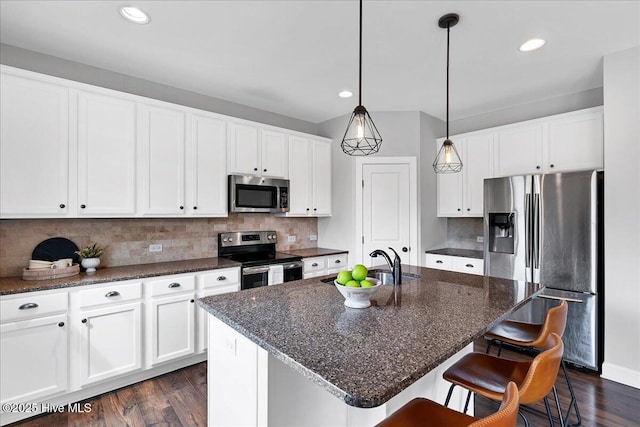 kitchen with backsplash, appliances with stainless steel finishes, and dark wood finished floors