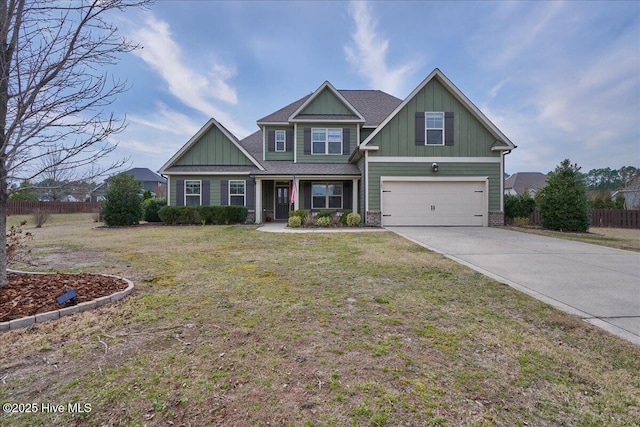 craftsman inspired home featuring board and batten siding, a front lawn, fence, a garage, and driveway