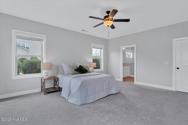 carpeted bedroom featuring visible vents, a ceiling fan, ensuite bathroom, and baseboards