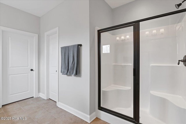bathroom with baseboards and a stall shower