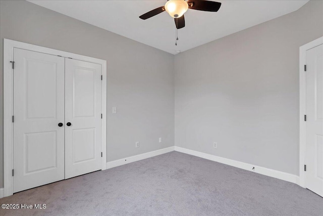 unfurnished bedroom featuring a closet, baseboards, carpet, and a ceiling fan