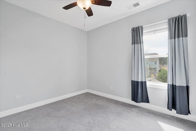 carpeted spare room with baseboards, visible vents, and ceiling fan
