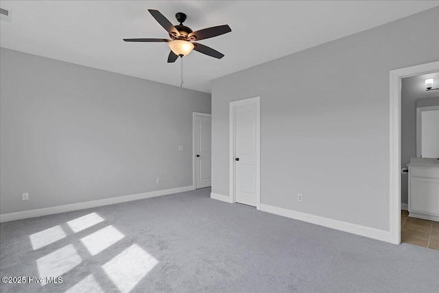 unfurnished bedroom featuring visible vents, ensuite bath, carpet floors, baseboards, and ceiling fan