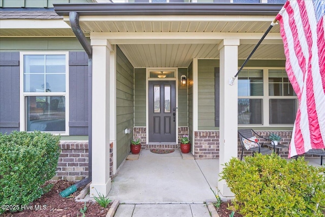 entrance to property with brick siding and covered porch