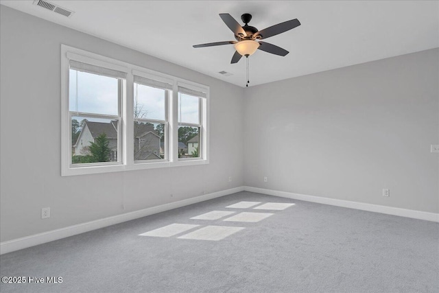 spare room featuring visible vents, baseboards, ceiling fan, and carpet flooring