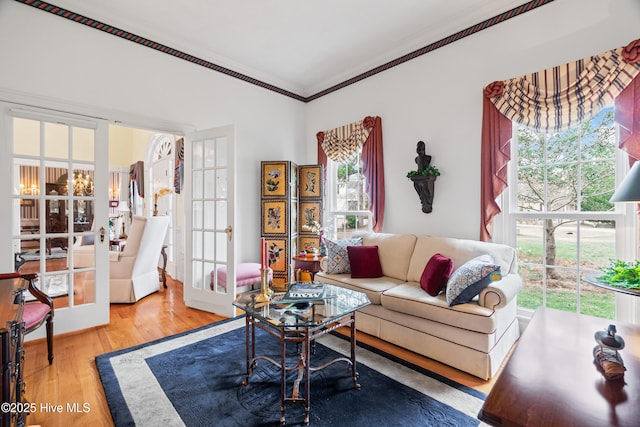 living room with a chandelier, ornamental molding, and wood finished floors
