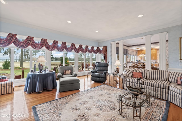 living room with recessed lighting, wood finished floors, ornate columns, and ornamental molding