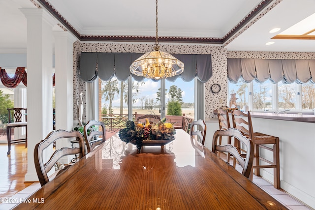 dining space with wallpapered walls, an inviting chandelier, crown molding, and baseboards