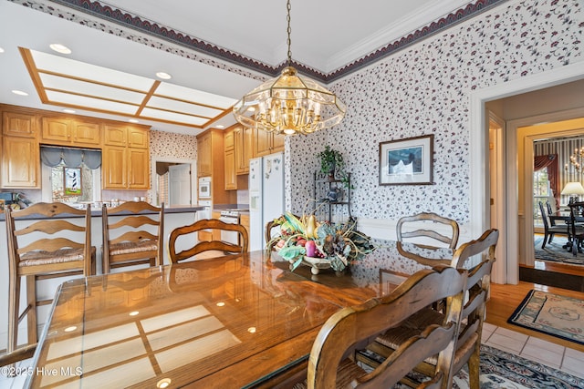 dining room with a notable chandelier, a healthy amount of sunlight, wallpapered walls, and crown molding