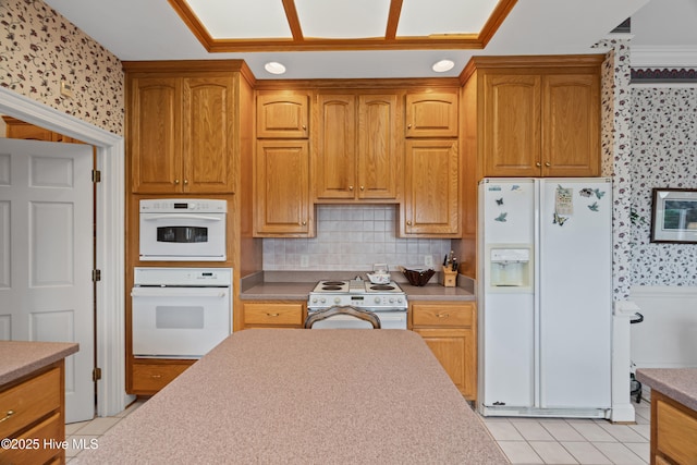 kitchen featuring white appliances, wallpapered walls, light tile patterned floors, decorative backsplash, and light countertops