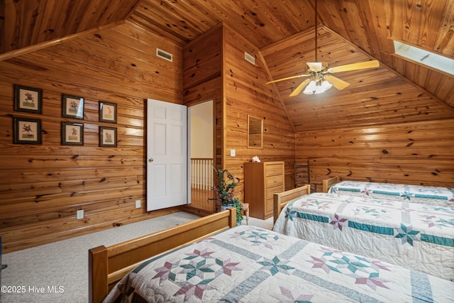 bedroom with wooden ceiling, wooden walls, visible vents, and ceiling fan