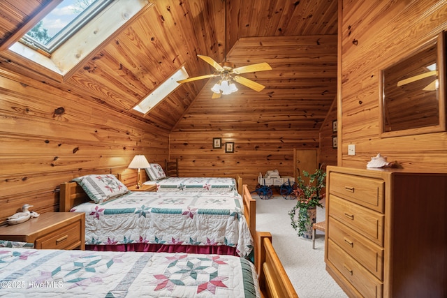 carpeted bedroom featuring wooden ceiling, vaulted ceiling with skylight, wooden walls, and ceiling fan