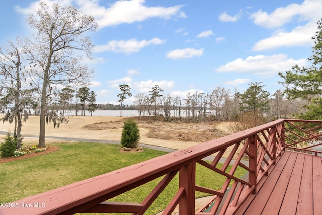 wooden terrace with a yard and a water view
