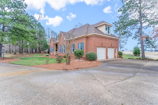 view of home's exterior with a yard, brick siding, concrete driveway, and an attached garage