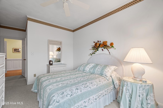 carpeted bedroom featuring crown molding and ceiling fan