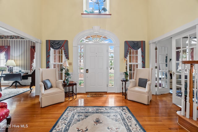 entryway with a wealth of natural light, a high ceiling, and wood finished floors