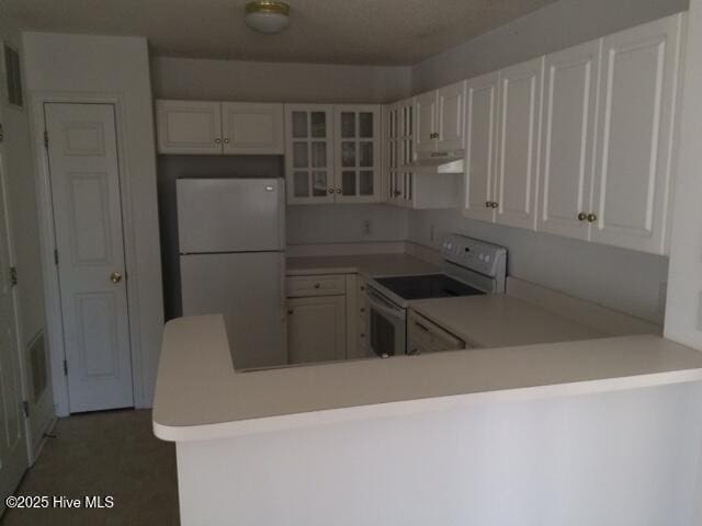527 Spring Forest Rd Unit F, Greenville, NC 27834 - kitchen featuring white appliances, ventilation hood, light countertops, glass insert cabinets, and a peninsula