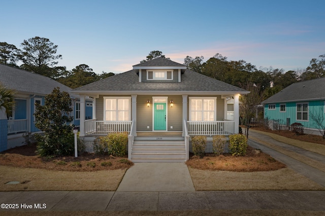 bungalow with covered porch and roof with shingles