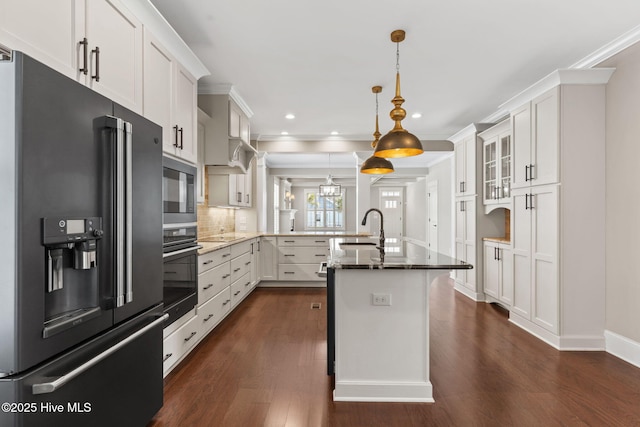 kitchen with black appliances, a sink, a peninsula, white cabinets, and glass insert cabinets