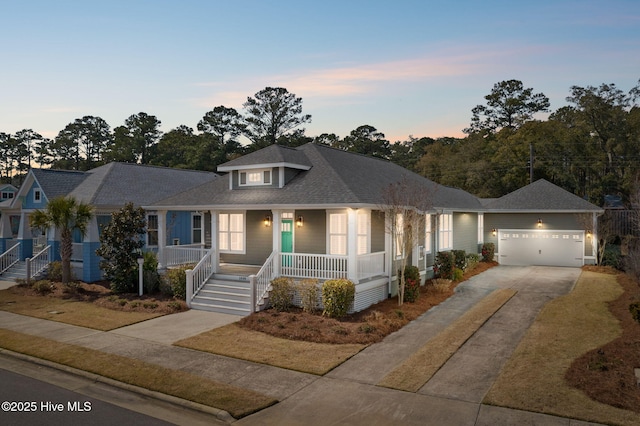 view of front of property with a garage, covered porch, driveway, and a shingled roof