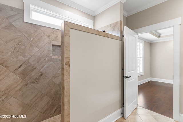 full bath featuring tile patterned flooring, crown molding, baseboards, and walk in shower