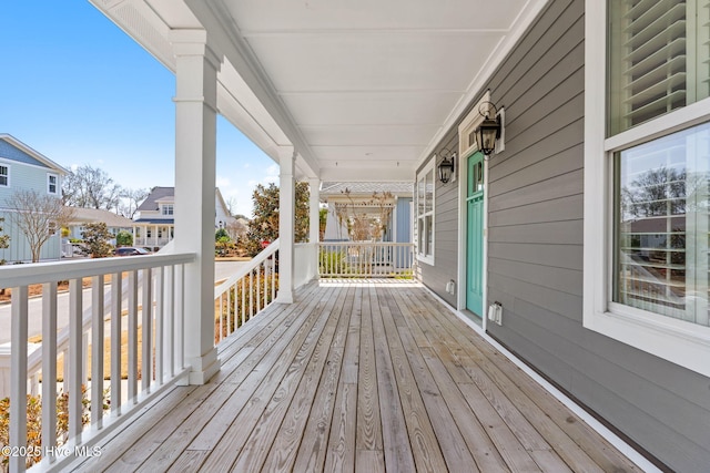 wooden terrace featuring a residential view and a porch