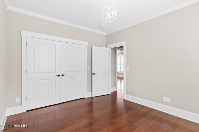 unfurnished bedroom with baseboards, a notable chandelier, wood finished floors, and crown molding