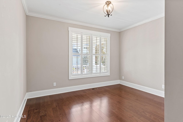 unfurnished room with dark wood-style floors, visible vents, baseboards, and ornamental molding