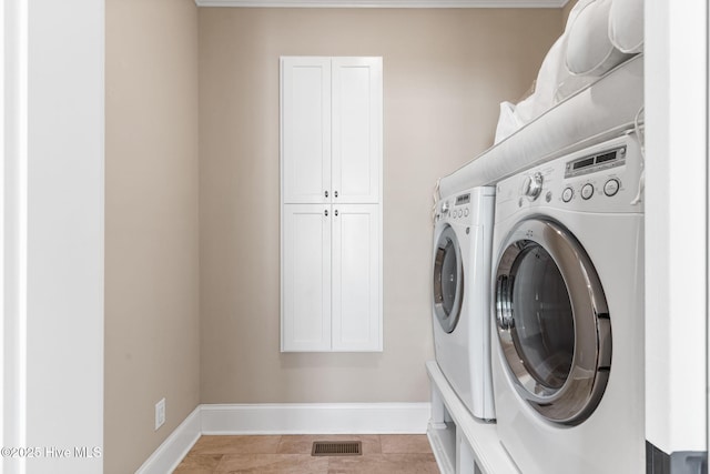 laundry room featuring visible vents, cabinet space, baseboards, and washing machine and clothes dryer