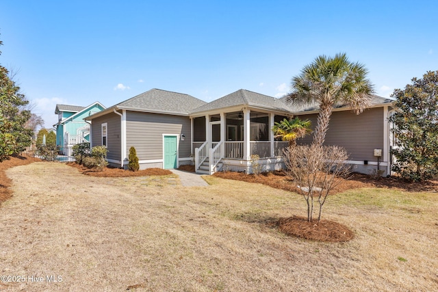 rear view of property featuring a lawn, roof with shingles, ceiling fan, and a sunroom