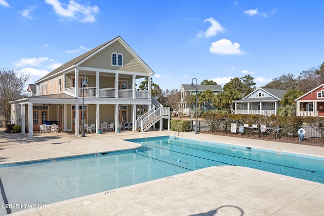 pool featuring a patio, stairs, and fence