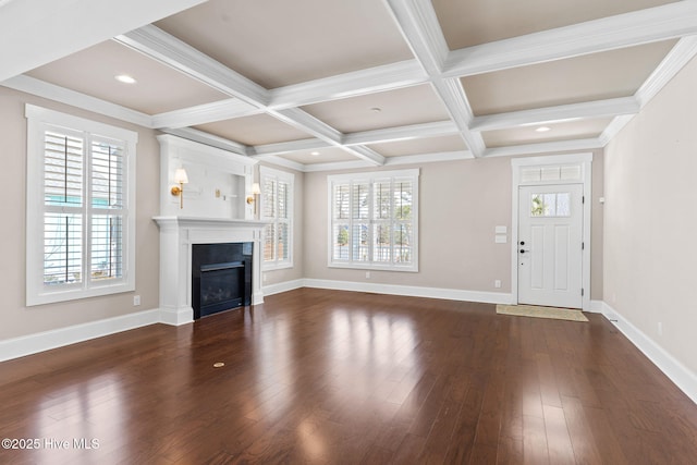 unfurnished living room with plenty of natural light, dark wood-type flooring, beam ceiling, and coffered ceiling