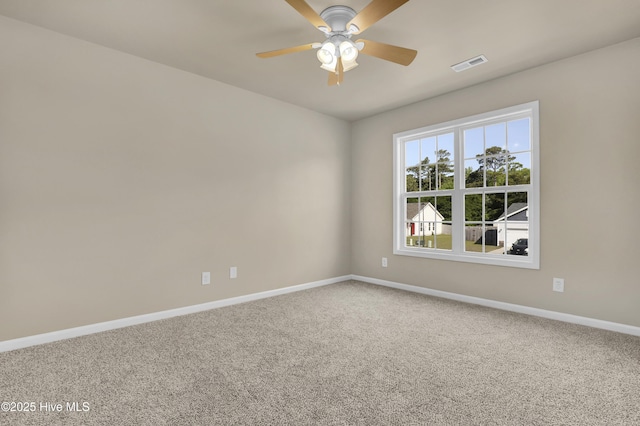 carpeted spare room with baseboards, visible vents, and ceiling fan