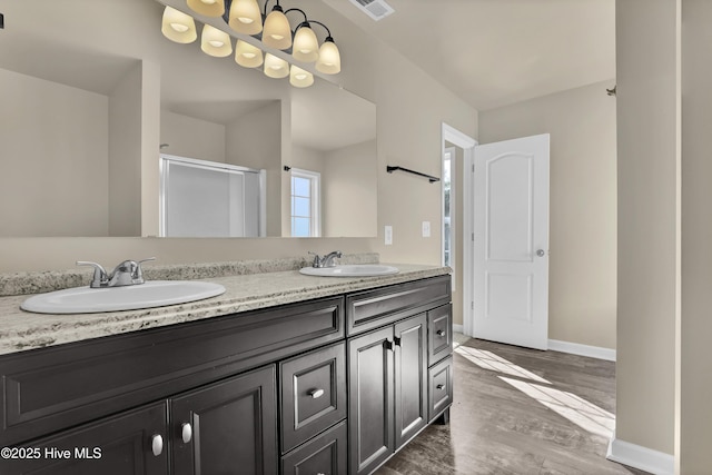 bathroom with visible vents, a shower stall, a sink, and wood finished floors