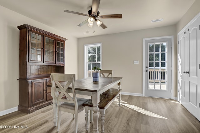 dining area with a ceiling fan, baseboards, visible vents, and light wood-style flooring