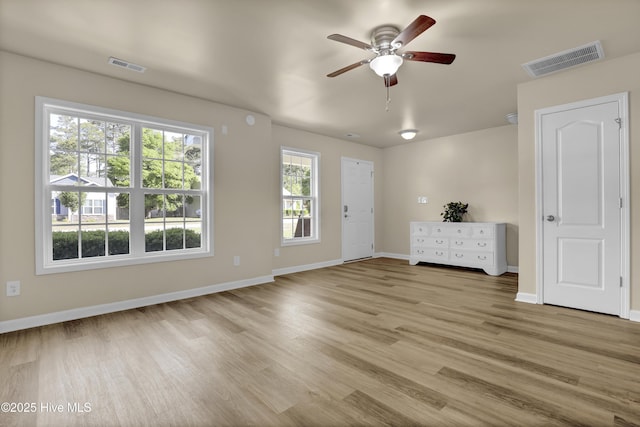 spare room featuring visible vents, a ceiling fan, baseboards, and light wood-type flooring