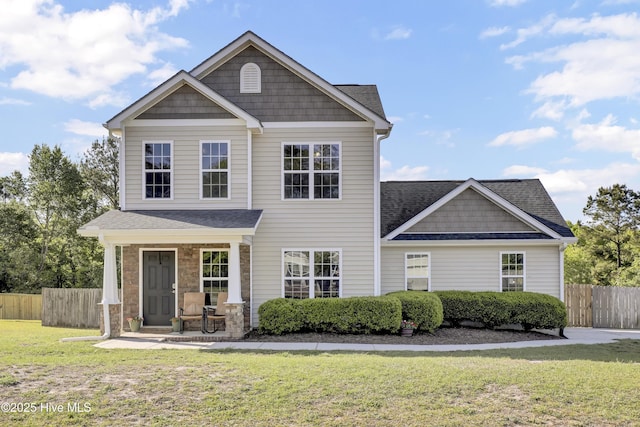 view of front of home featuring a porch, a front lawn, roof with shingles, and fence