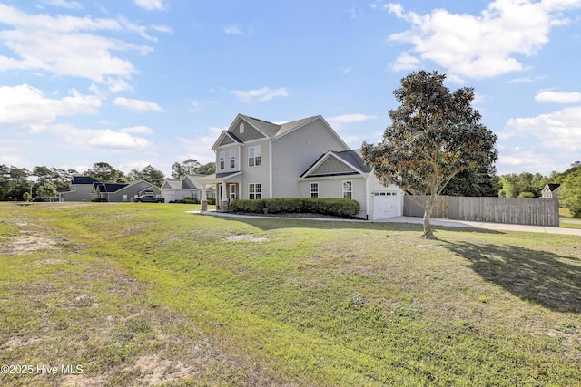 traditional-style home with a garage, a front lawn, fence, and driveway
