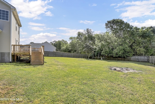 view of yard featuring a fenced backyard, a wooden deck, and stairs