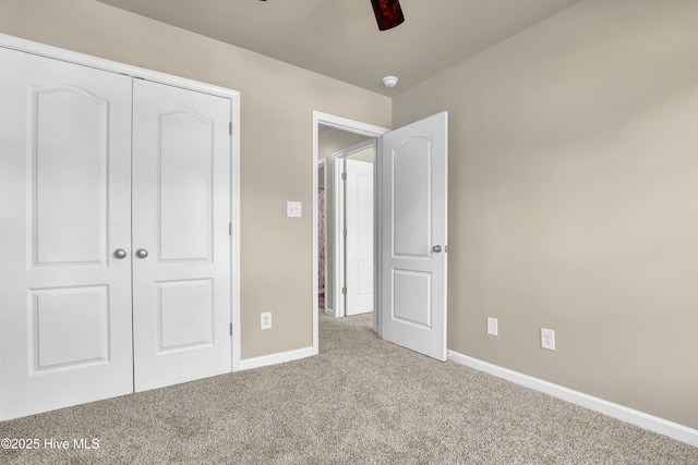 unfurnished bedroom featuring carpet floors, a ceiling fan, baseboards, and a closet