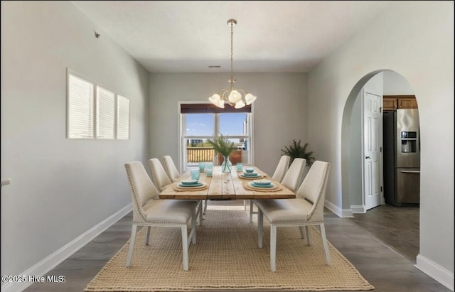 208 Carolina Beach Ave S # 300, Carolina Beach, NC 28428 - dining room featuring arched walkways, a chandelier, baseboards, and dark wood-style flooring