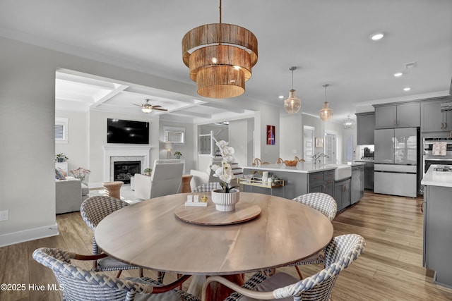 410 Sugar Cv, Wilmington, NC 28411 - dining room featuring ceiling fan, a premium fireplace, recessed lighting, crown molding, and light wood-style flooring