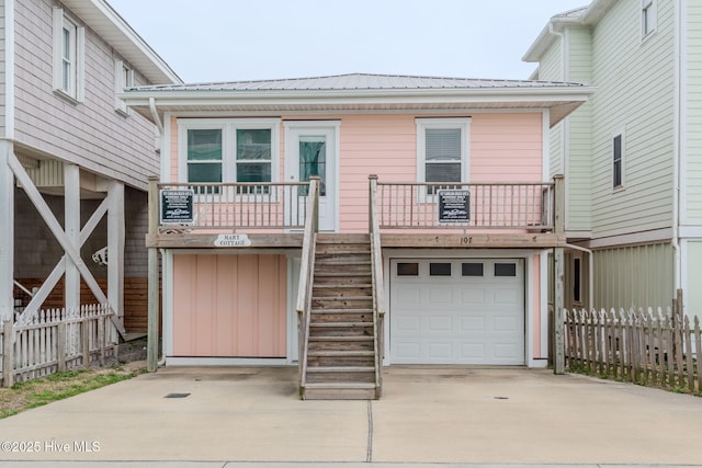 107 Carolina Beach Ave S, Carolina Beach, NC 28428 - view of front facade with fence, concrete driveway, stairs, and a garage