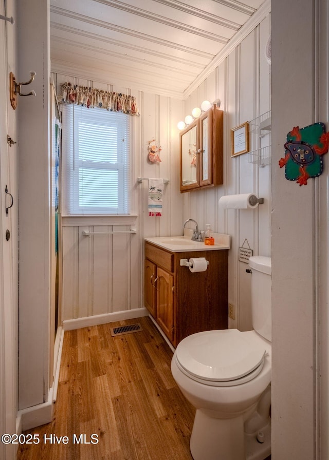 107 Carolina Beach Ave S, Carolina Beach, NC 28428 - bathroom featuring wood finished floors, visible vents, toilet, vanity, and crown molding