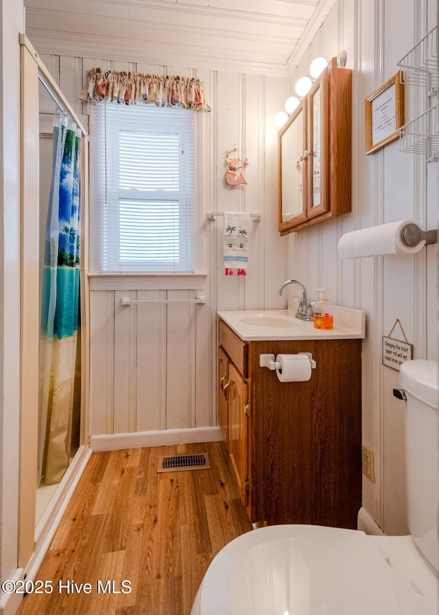 107 Carolina Beach Ave S, Carolina Beach, NC 28428 - full bath featuring toilet, wood finished floors, curtained shower, crown molding, and a decorative wall