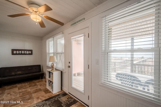 107 Carolina Beach Ave S, Carolina Beach, NC 28428 - doorway to outside with ceiling fan, crown molding, stone finish floor, and wooden walls