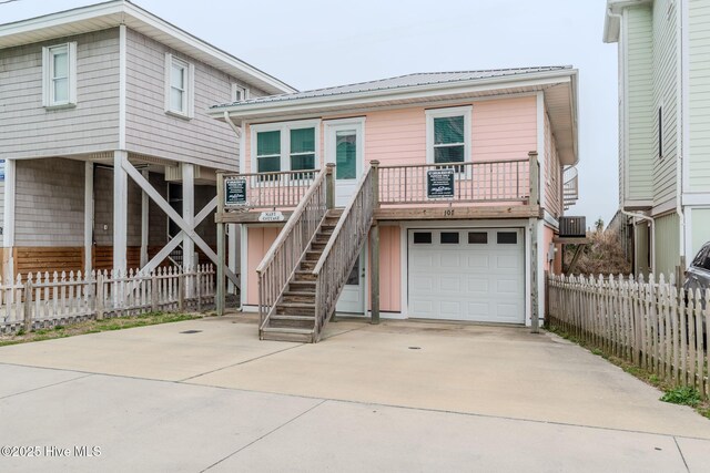 107 Carolina Beach Ave S, Carolina Beach, NC 28428 - view of front facade featuring concrete driveway, central air condition unit, an attached garage, fence, and stairs