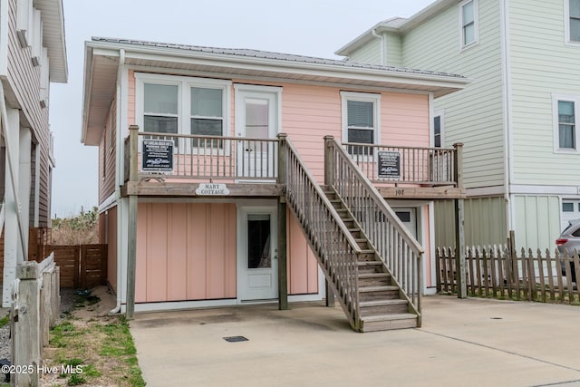 107 Carolina Beach Ave S, Carolina Beach, NC 28428 - back of property with board and batten siding, a patio area, stairway, and fence